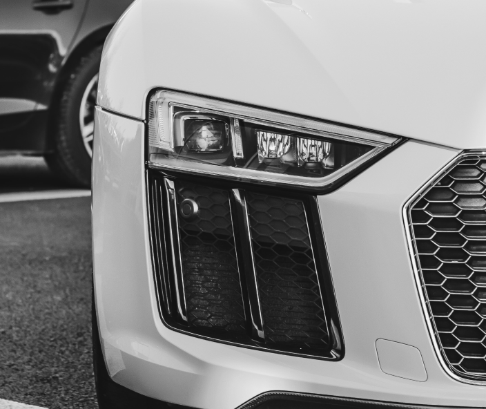 The left headlight of a white car